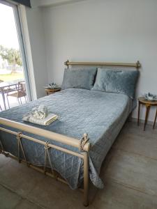 a bed with a blue comforter in a bedroom at MG Villa Kineta in Kineta