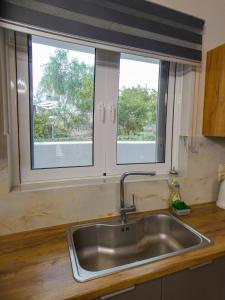 two windows in a kitchen with a sink at MG Villa Kineta in Kineta