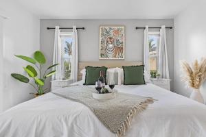 un letto bianco con un tavolo con sopra delle bottiglie di vino di Waterfront Living, Dock, Heated Pool & Spa - Gulf Gate Oasis - Roelens a Cape Coral Altre 54 foto
