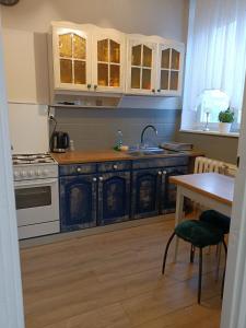 een keuken met witte kasten, een wastafel en een tafel bij Duża kawalerka Kossaka 12B -balkon -dla max 4osób przy galeri kasztanowa Centrum in Piła