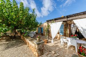 un patio con mesa, sillas y árboles en YourHouse Sa Estada villa, en Sineu