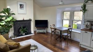 un soggiorno con un tavolo e una televisione di The Arch House a Enniskerry