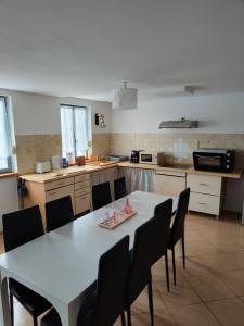 a kitchen with a white table and chairs in it at Cosy Ciné 8 in Pont-de-lʼArche