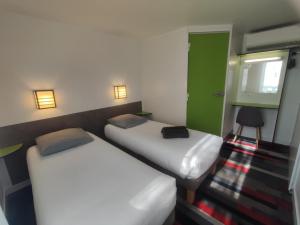 a room with two beds and a green door at Kyriad Direct Saintes in Saintes +28 photos
