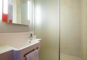 a bathroom with a sink and a shower at B&B HOTEL La Rochelle Beaulieu Puilboreau in Puilboreau