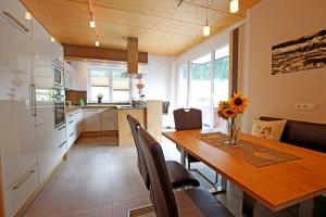 eine Küche und ein Esszimmer mit einem Holztisch und Stühlen in der Unterkunft Apart Belmont in Pfunds