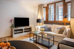 a living room with a white couch and a tv at Ferienwohnung Gasthaus zum Kranz in Freiburg im Breisgau