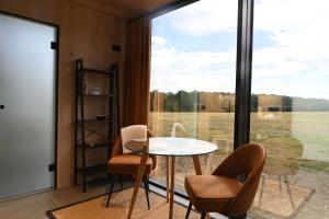 a room with a table and chairs and a large window at Mirror Houses Pound Farm - Meadow OOD in Saxmundham