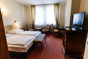 a hotel room with two beds and a flat screen tv at Schloss Neckarbischofsheim in Neckarbischofsheim