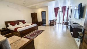 a bedroom with a bed and a bathroom with a sink at VALLEY VIEW INN, Kotagiri in Kotagiri