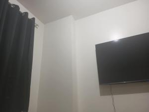 a flat screen tv hanging on a white wall at Amaia Steps Capitol Condo in Bacolod