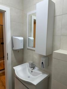 a bathroom with a white sink and a mirror at Aparte - Tophane in Pristina