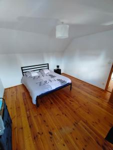 sypialnia z łóżkiem na drewnianej podłodze w obiekcie Cosy Triplex 3 chambres w mieście Pont-de-lʼArche