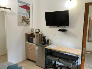 a room with a desk and a television on a wall at Charmante chambre indépendante, terrasse et entrée privative in Gujan-Mestras