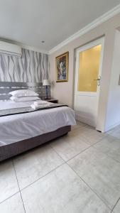 a bedroom with a large bed and a door at Studio on Albert, Hout Bay in Hout Bay +27 photos