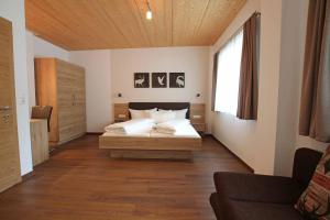 Schlafzimmer mit einem Bett und einem Fenster in der Unterkunft Apart Belmont in Pfunds
