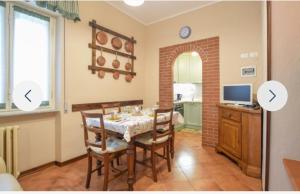 a dining room with a table and a kitchen at Casa Martina in Camaiore
