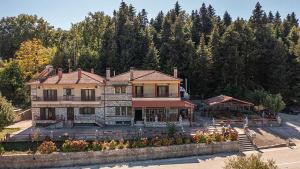 duży dom z drzewami w tle w obiekcie Guesthouse Moucha w mieście Moúcha