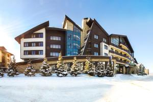 ein Gebäude mit Weihnachtsbäumen im Schnee in der Unterkunft Terra Hotel in Bansko