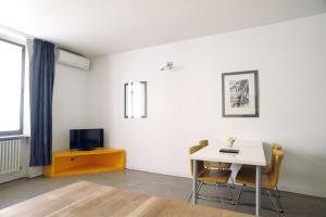 un salon avec une table et une armoire jaune dans l'établissement Sant Ambrogio Courtyard Room in shared flat, à Milan