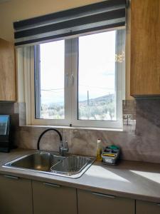 a kitchen counter with a sink and a window at MG Studio Kineta in Kineta