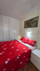 a bedroom with a red blanket with white stars on it at Tenerife cerca del aeropuerto in San Isidro