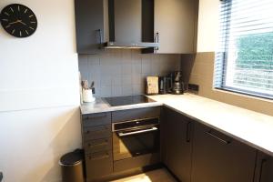a kitchen with a sink and a clock on the wall at Kustverhuur, Vakantiepark Fort Soleil 14 in Breskens