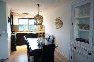 a dining room and kitchen with a table and chairs at Kustverhuur, Vakantiepark Fort Soleil 14 in Breskens