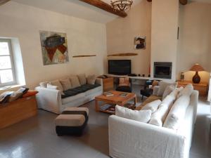 a living room with white couches and a tv at prestigious mas with heated swimming pool in oppède, in the heart of the luberon - 11 persons in Oppède