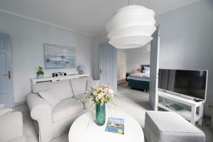 ein Wohnzimmer mit einem weißen Sofa und einem Fernseher in der Unterkunft Kappeln 333 in Kappeln + 19 Fotos