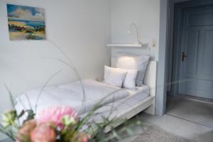 ein Bett mit weißen Laken und Kissen in einem Zimmer in der Unterkunft Kappeln 333 in Kappeln