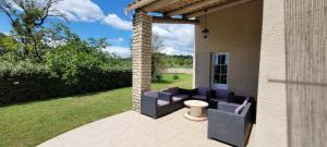 un patio con sofá, mesa y sillas en house in the countryside in the luberon with beautiful view and private swimming-pool close to bonnieux in Provence - 8 personnes, en Bonnieux