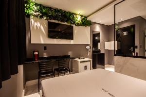 a room with a bar with chairs and plants on the wall at Motel Jardim Secreto in Santo André +28 photos