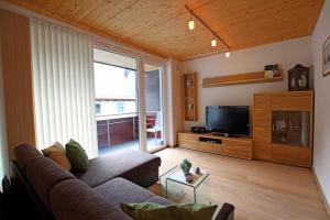 ein Wohnzimmer mit einem Sofa und einem TV in der Unterkunft Apart Belmont in Pfunds