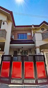 a house with red and red windows on the front at Spacious Apartment near Evia Daang Hari in Manila