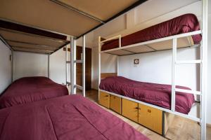 two bunk beds in a room with red sheets at Mistico Hostel 23 in El Chalten
