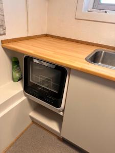a microwave oven sitting under a counter in a kitchen at 1-Room Apartment In City Center in Nuuk