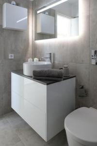 Un baño con lavabo, inodoro y espejo. en Avlia Panoramic Villa Naxos, en Naxos Chora 33 fotos más