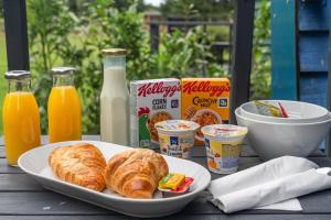 a table with a plate of croissants and orange juice at Whitemoss Lodge in Dunning