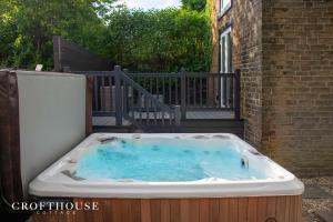 a hot tub sitting on the side of a building at Croft House Cottage in Halifax
