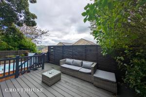 a patio with a couch on a wooden deck at Croft House Cottage in Halifax +32 photos