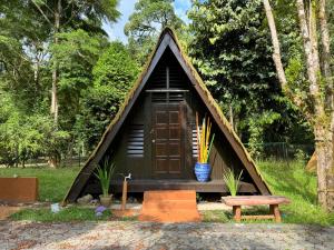 a small house with a door and a bench at Chalet Kuala Woh Resort in Tapah