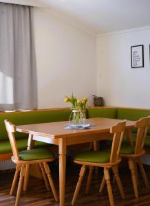 a table and chairs with a vase of flowers on it at Ferienhaus Bucheggerhof in Schladming