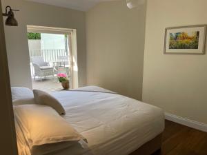 un letto bianco in una camera con patio di The Arch House a Enniskerry