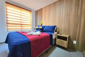 a bedroom with a bed with blue and red sheets at Rooftop Tamandaré by Temporada Inn in Tamandaré +231 photos