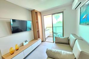 a living room with a couch and a flat screen tv at Rooftop Tamandaré by Temporada Inn in Tamandaré
