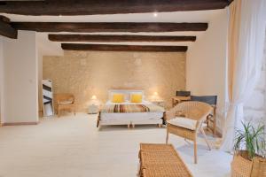a bedroom with a bed and chairs in a room at Gite d'ici et d'ailleurs in Brantôme