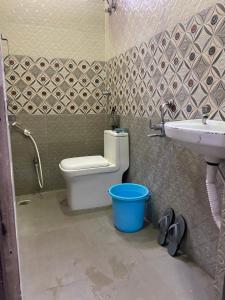 a bathroom with a toilet and a sink and a bucket at SRT HOMELY STAY WITH All AMENITIES in Hyderabad +41 photos