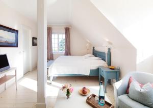a white bedroom with a bed and a couch at Hotel & Restaurant Ole Liese in Panker