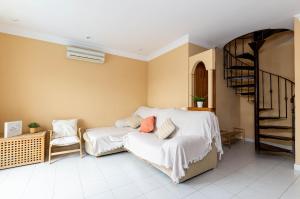 a bedroom with a bed and a chair and a staircase at Yourhouse El Xiprer in Pollença